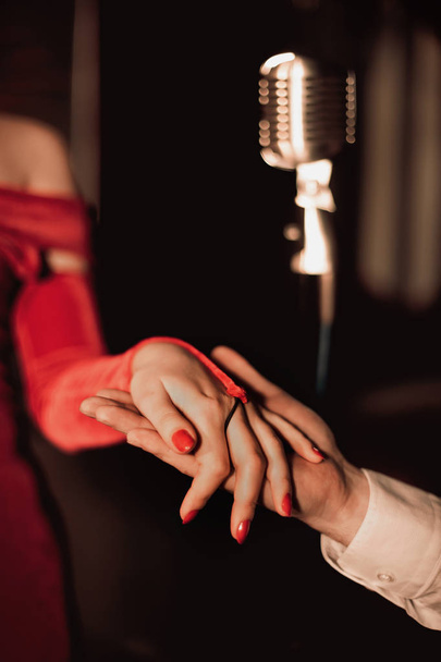 eski stil, retro, tutar kızın elini, arka plan, eski bar, kırmızı elbiseli kız mikrofon adam - Fotoğraf, Görsel