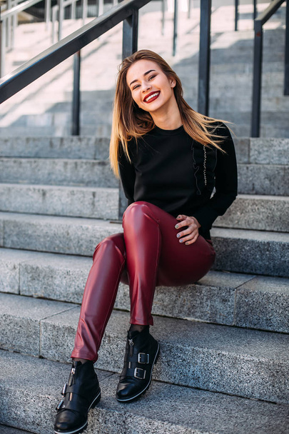 young attractive stylish smiling woman having fun in city , positive, emotional, wearing leather shorts and black sweatshirt bright red lips. style fashion trend. - Foto, Imagem