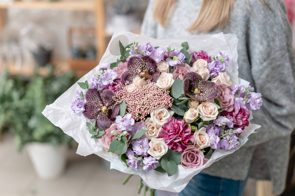 pięknych świeżych ciętych bukiet kwiatów mieszane w ręce kobiety. Praca w kwiaciarni Kwiaciarnia. Delikatne pastelowe odcienie kolorów - Zdjęcie, obraz
