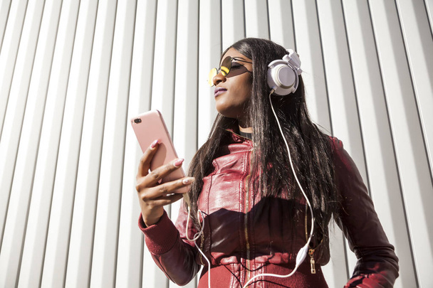 Krásná mladá žena, která poslouchala hudbu se sluchátky - Fotografie, Obrázek