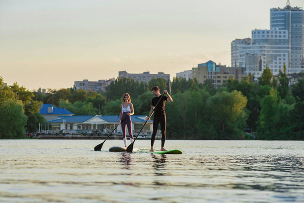 Happiness boy and girl on sup surf swimming at the river. Concept lifestyle, sport, love - Foto, Bild