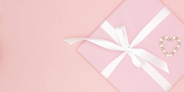 Día de San Valentín decoración en la mesa vista superior de fondo. Composición plana de forma roja corazón y caja de regalo rosa con fondo de papel de coral de cinta blanca para maquillar su diseño. Concepto de día de amor
 - Foto, Imagen