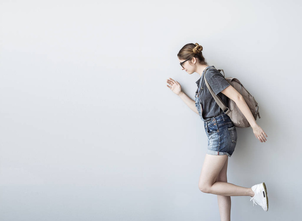 Studentka s batohem pěšky izolovaných na bílém pozadí - Fotografie, Obrázek