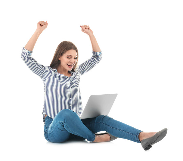 Emotional young woman with laptop celebrating victory on white background - Foto, Bild