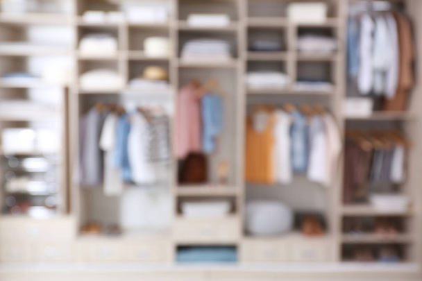 Vista borrosa del armario grande con ropa y cosas para el hogar
 - Foto, Imagen