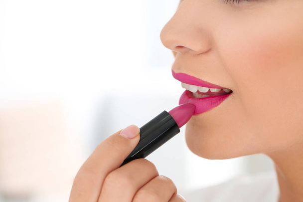 Beautiful woman applying lipstick on light background, closeup - Φωτογραφία, εικόνα