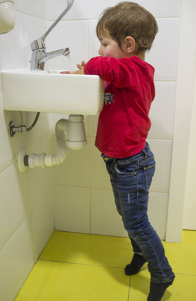 3 roky dítěte/boy mytí rukou u dřezu přizpůsobeny školy ale dosáhne jen stěží do pánve. Problémy na upravené toalety pro děti - Fotografie, Obrázek