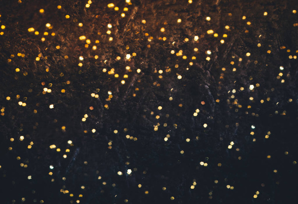 Sparkling golden particles explosion. Glowing bokeh lights abstract background - Photo, Image