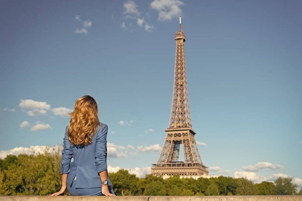 Frau in blauem Kleid schaut auf den Eiffelturm in Paris. Frau mit langen Haaren, Frisur, Rückansicht, Schönheit. Mode, Stil, Trend. Schönheit, Aussehen, Haare, Frisur. Urlaub, Reise, Reise - Foto, Bild