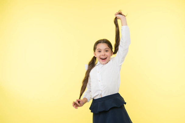 Comfortable and easy hairstyle. Deal with long hair hairstyle by yourself. Kid girl long ponytail hairstyle. Child school uniform make hairdo. Kid stylish fashionable posing hold ponytails hairstyle - Photo, image