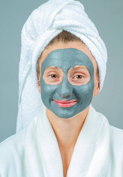 Spa Clay Mask. Beautiful young woman with clay facial mask. Skincare and beauty Concept. - Фото, зображення