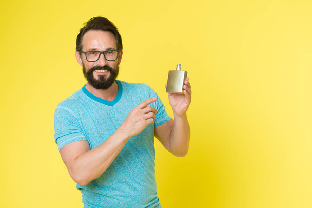 Man bearded handsome hold bottle perfume. How choose perfume for men according to occasion. Make sure smell fresh throughout day. Wearing perfume is enhancing mood. Amazing benefits of using perfumes - Fotó, kép