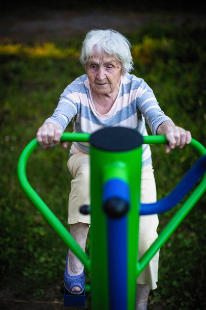 Mulher idosa se exercita no playground do esporte de rua
. - Foto, Imagem