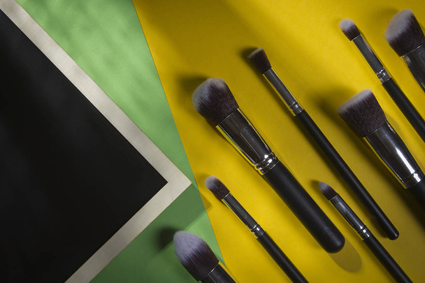 A set of cosmetic brushes on a yellow-green background - 写真・画像