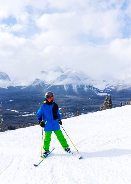 Young skier at the top of a mountain range in Lake Louise in the Canadian Rockies of Alberta, Canada. - Photo, Image