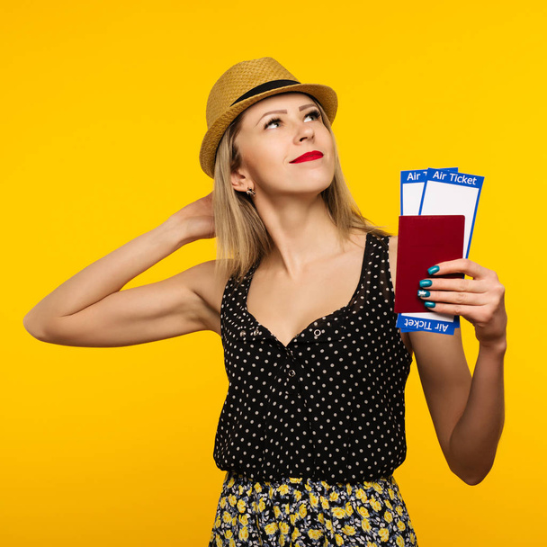 Young smiling excited woman student holding passport boarding pass ticket isolated on yellow background. Education in university college abroad. Air travel flight - Image - 写真・画像