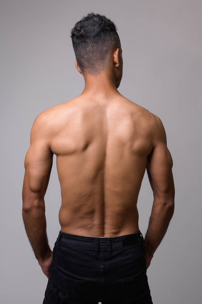 Rear view of young muscular Persian man shirtless - Фото, зображення