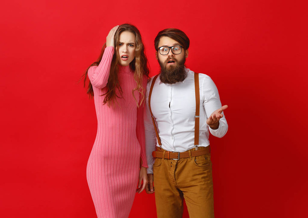 couple de jeunes personnes émotionnelles homme et femme sur fond rouge
 - Photo, image