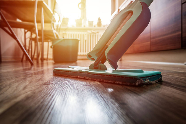 Wiping dirty wooden floor by wet wiper mop, housework - Valokuva, kuva