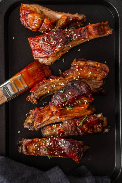 Delicious barbecued ribs seasoned with a spicy basting sauce. lose-up, copy space. - Foto, Imagen