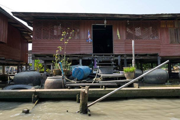 Casas e casas nas proximidades da água do canal em Damnoen Saduak Mercado flutuante, Tailândia
 - Foto, Imagem