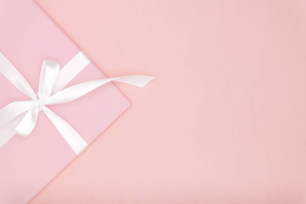 Pink gift or present box flat lay composition for Valentine day or women day, greeting card birthday with copy space on coral background. Concept holiday decoration top view for Christmas, love day.  - Photo, Image