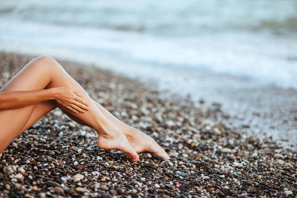 Womens beautiful sexy legs on the beach - Foto, afbeelding