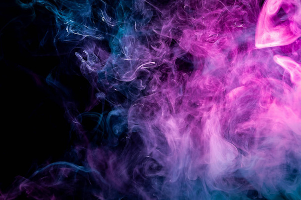 Fumo denso multicolore di colori rosa e blu su uno sfondo nero isolato. Sfondo di fumo vap
 - Foto, immagini