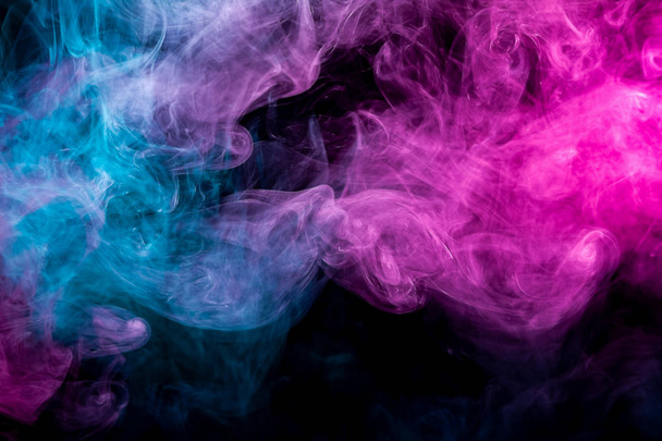 Espeso humo de color rosa y azul en forma de cielo sobre un fondo negro aislado. Fondo del humo del vapor. Mocap para camiseta fresca
 - Foto, Imagen