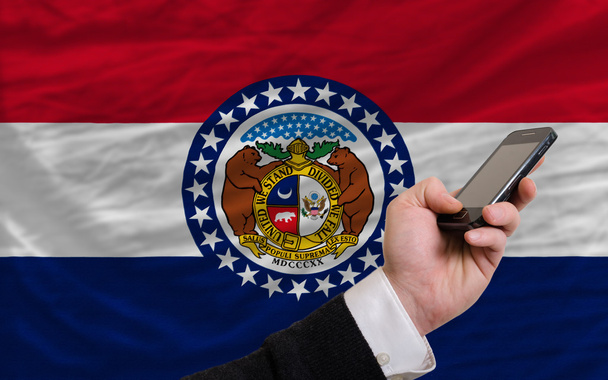teléfono celular en frente de la bandera del estado americano de Missouri
 - Foto, imagen