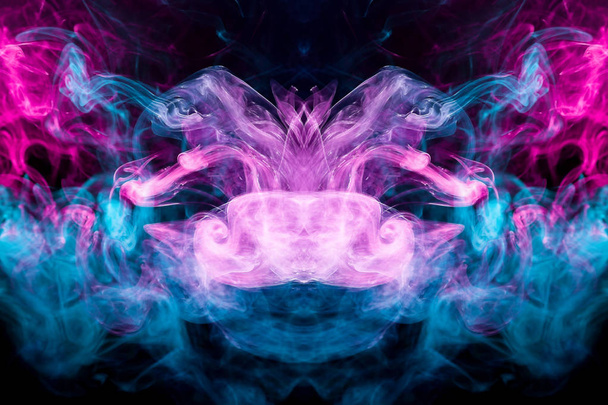Espeso humo colorido de color azul, rosa en forma de un cráneo, monstruo, dragón sobre un fondo negro aislado. Fondo del humo del vapor. Mocap para camiseta fresca
 - Foto, Imagen