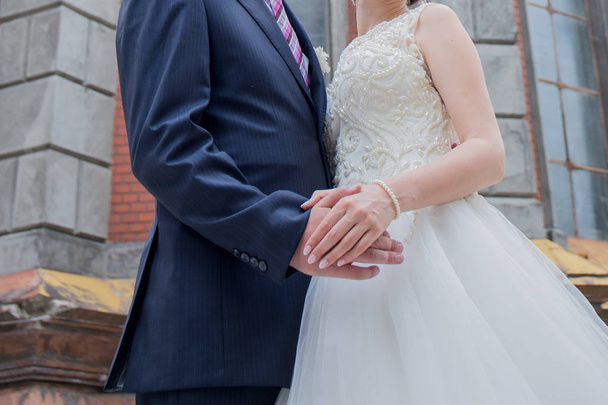 newlyweds stand together near building in city - Foto, imagen