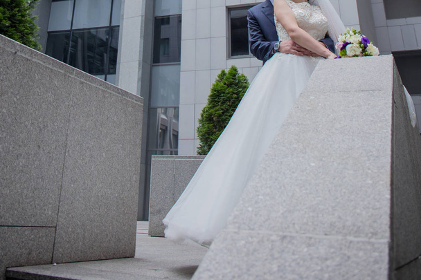 newlyweds stand together near building in city - Photo, image