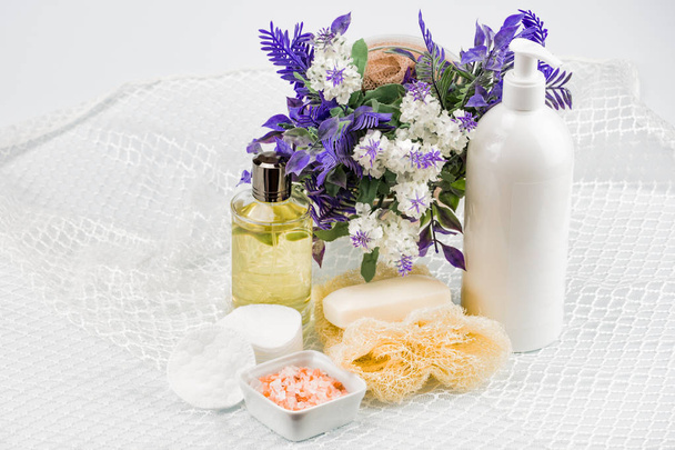 Bath accessories on the lace, top view side. Good morning and good mood. Near a vase of flowers. The background is white, blurred. There is a place for signature - Photo, Image