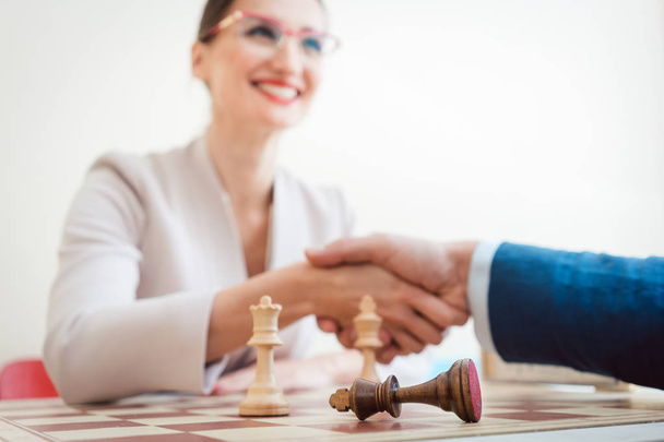 Business man and woman handshaking after game of chess - Photo, Image