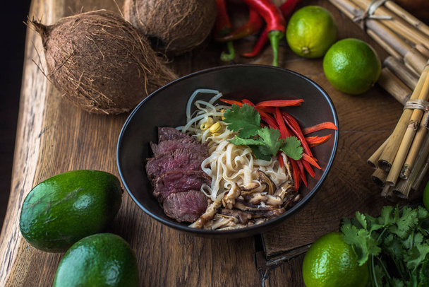 Vietnamese  Pho soup in black bowl on wooden table - Foto, immagini