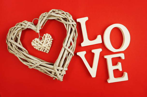 wicker heart and love word decoration made with filter color on red background - Φωτογραφία, εικόνα