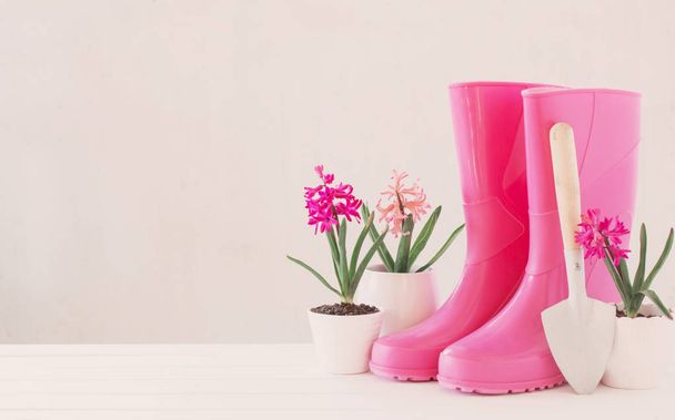 rubber boots and spring flowers on white background - Foto, Imagen