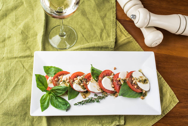 Traditional italian caprese with mozzarella and tomatoes on white platter - Foto, Imagen