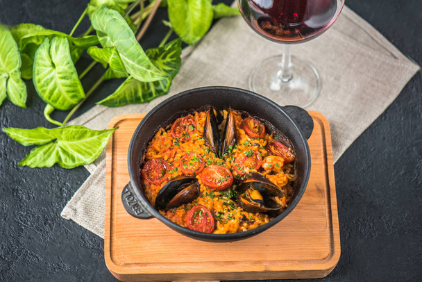 traditional seafood paella in pot on wooden board - 写真・画像