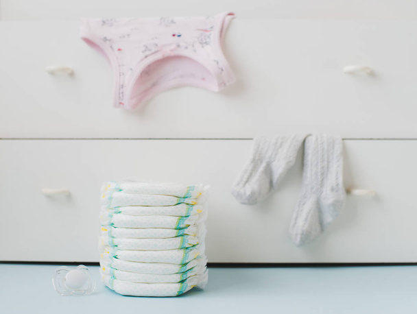 A stack of diapers and a locker with linens - Foto, afbeelding