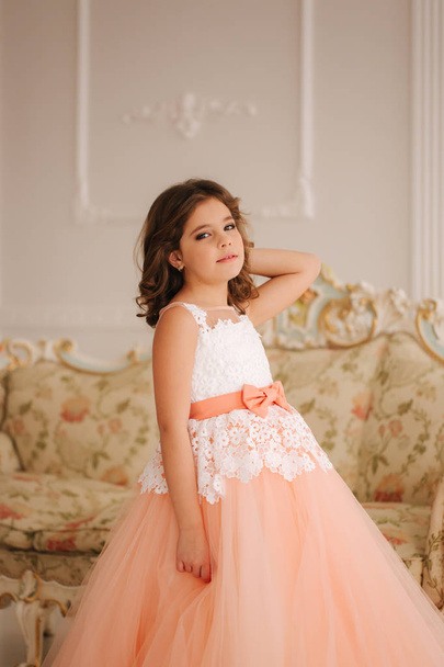 glückliche kleine Prinzessin in schönem Kleid spaziert durch das große Studio - Foto, Bild