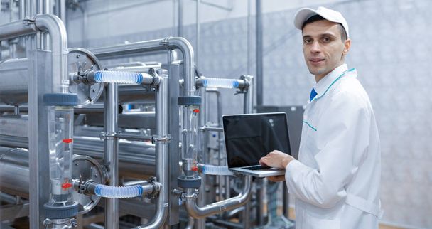 Technologue avec un ordinateur portable dans ses mains à l'usine laitière
 - Photo, image