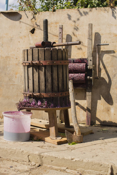 Elaboración de vino. Tecnología de producción de vino. La tradición popular de hacer vino. Producción de vino en Moldavia. La antigua tradición del procesamiento de la uva. El exprimidor se utiliza para presionar el vino
.  - Foto, Imagen