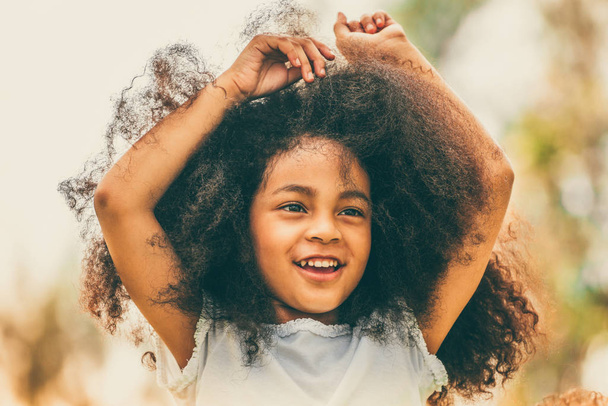 屋外の公園で遊んで幸せなアフリカ系アメリカ人の子供の肖像画。自由と子供の健康概念. - 写真・画像