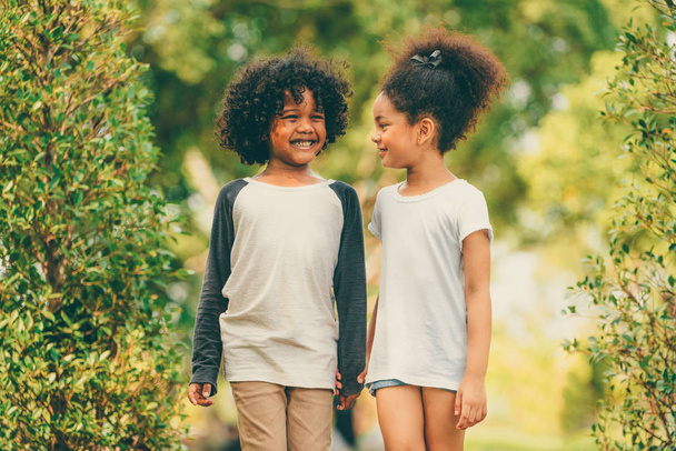 Menino e menina felizes no parque. Duas crianças afro-americanas juntas no jardim
. - Foto, Imagem