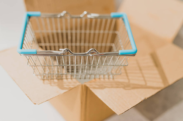 delivery parcel box with shopping basket, concept of online purchases and shipping - 写真・画像