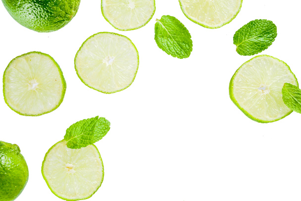 Fresh lime slice with mint leaves isolated on white background, top view copy space. Summer refreshment cocktail ingredient concept. - Φωτογραφία, εικόνα