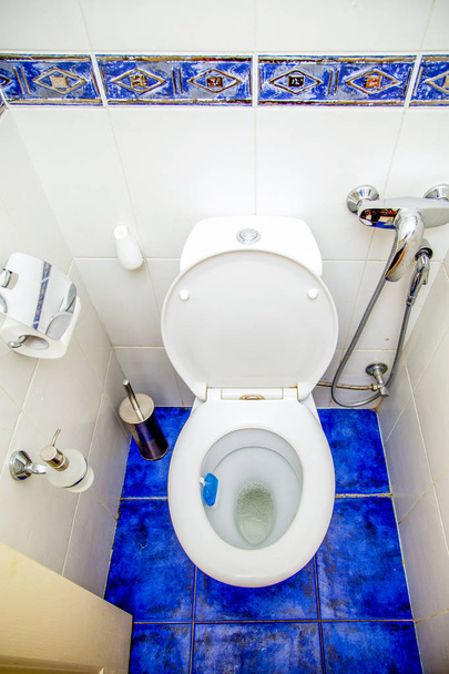 modern toilet room - toilet, bidet, air freshener, towel and other, decorated with white tiles with blue decor, top view - Photo, image