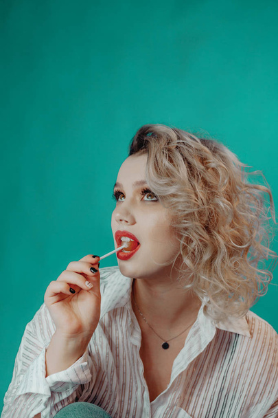 Girl with red lips and freckles, licks lollipop - Zdjęcie, obraz